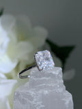 Diamond ring on a crystal with white flowers in the background