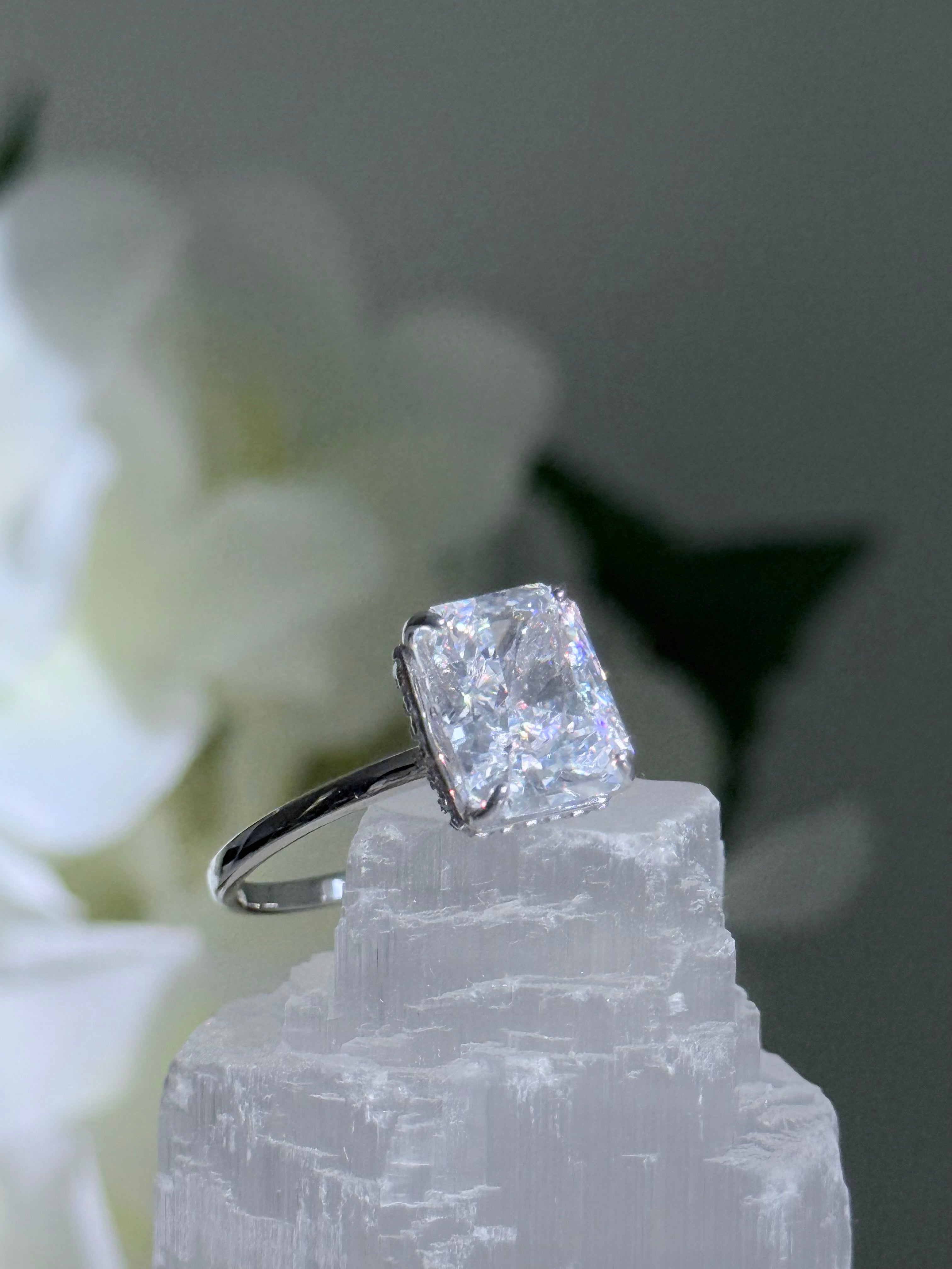 Diamond ring on a crystal with white flowers in the background