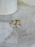 Gold ring with a large diamond on a marble surface