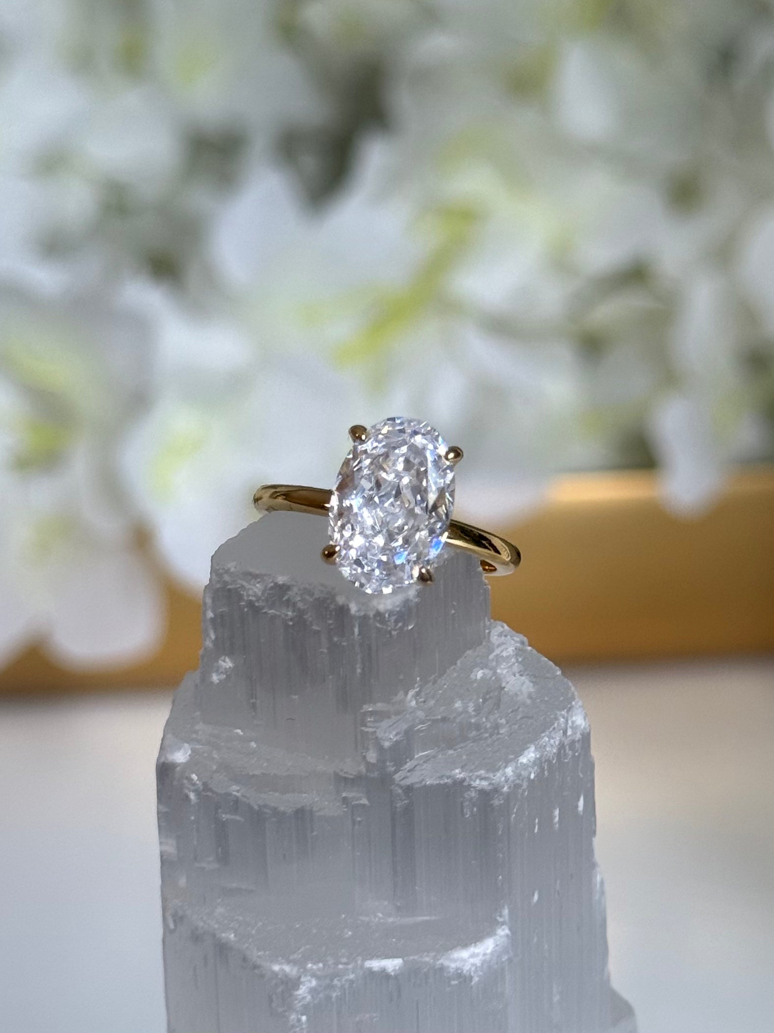Diamond ring on a crystal with blurred flowers in the background