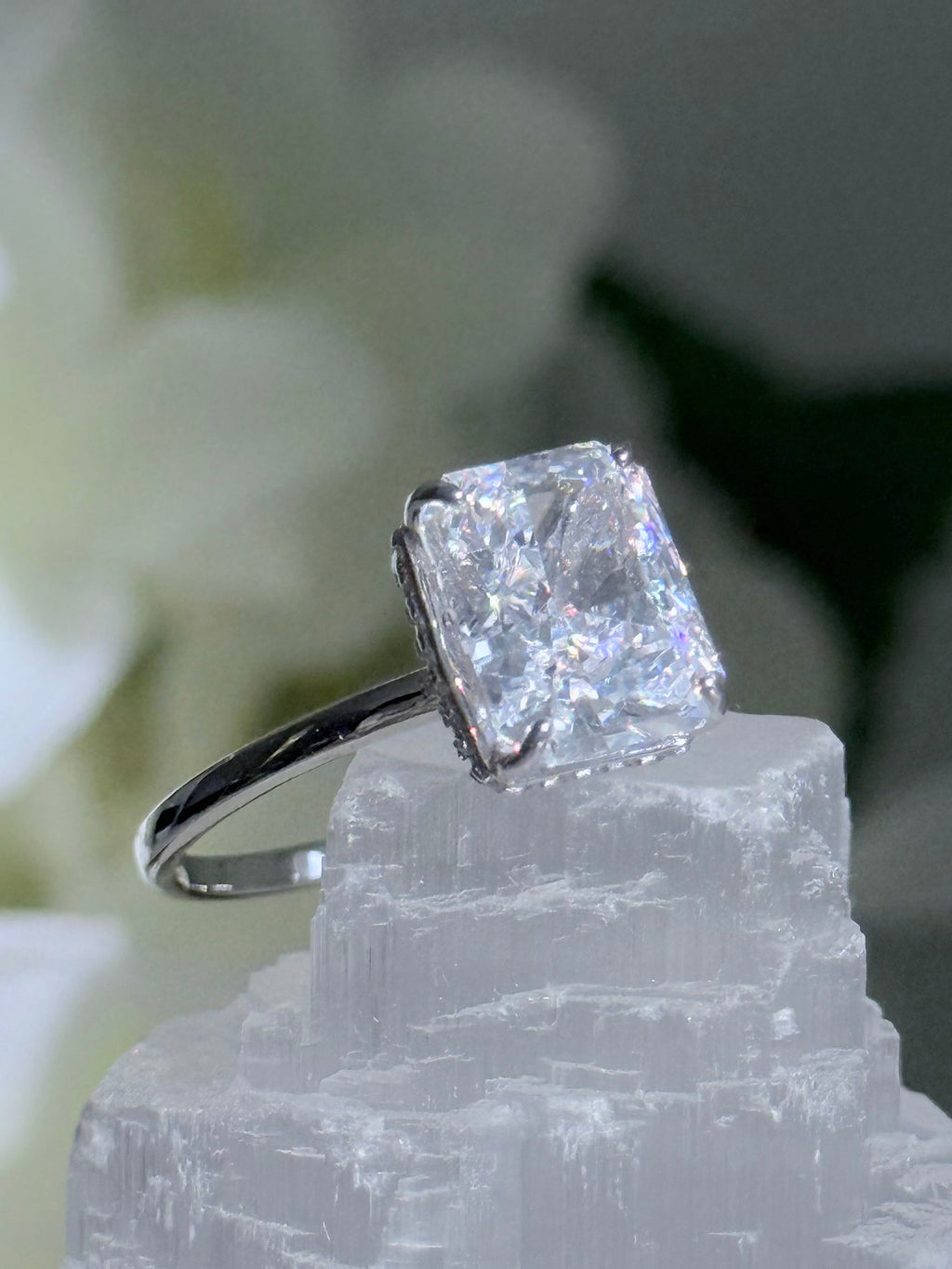 Diamond ring on a crystal with white flowers in the background