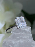 Diamond ring on a crystal with white flowers in the background