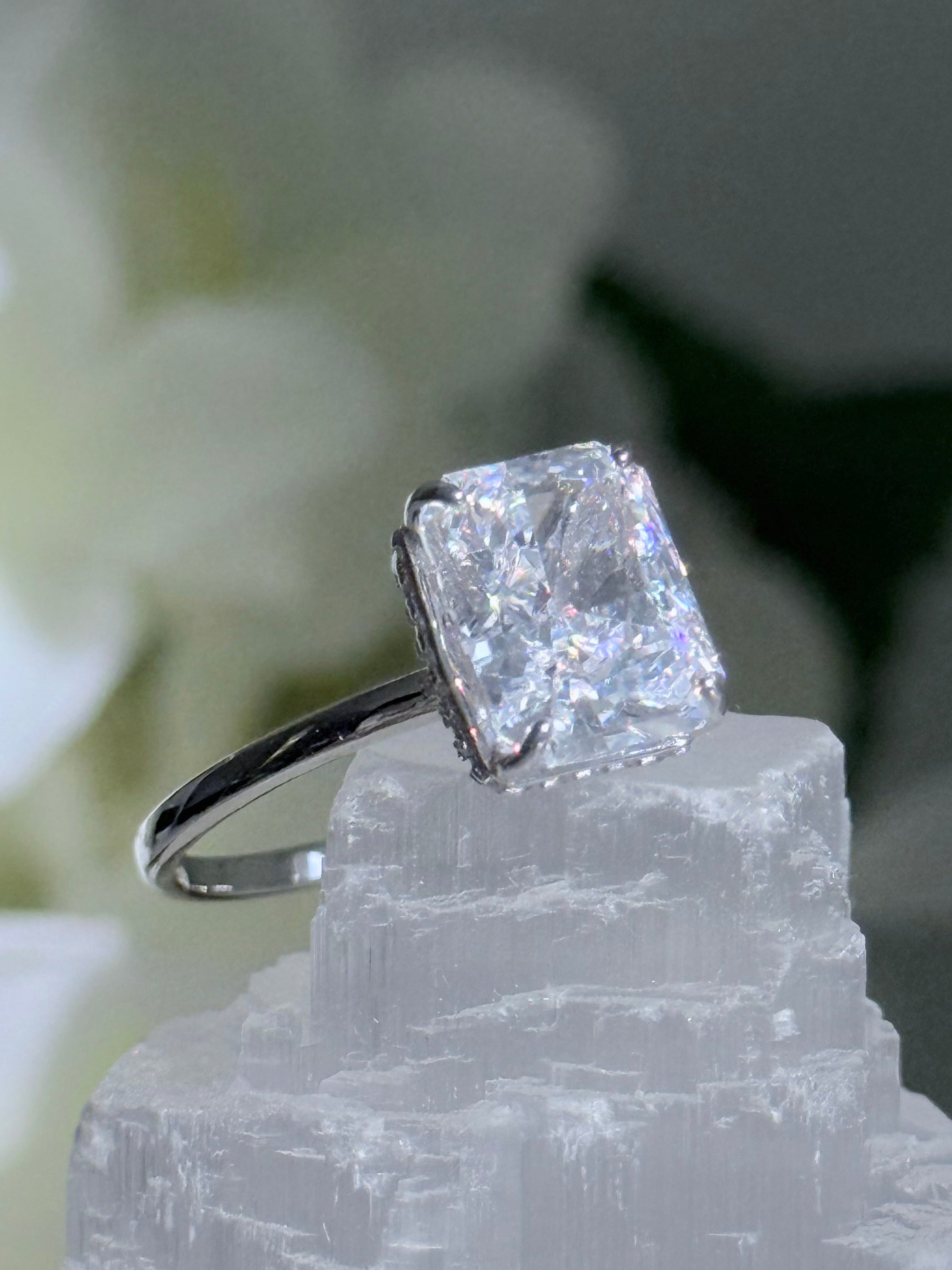 Diamond ring on a crystal with white flowers in the background