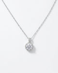 Silver necklace with a round diamond pendant on a light gray background