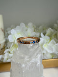 Gold ring with blue stones on a crystal and flower background