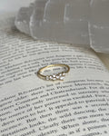 Gold ring with diamonds on an open book