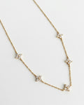 Gold necklace with star-shaped pendants on a light gray background