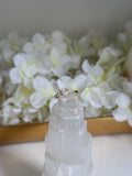 Diamond ring on a decorative crystal with white flowers in the background